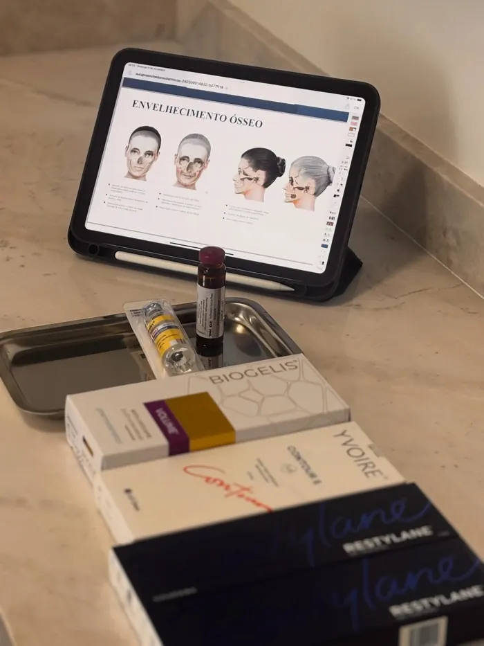 Tablet com aula de envelhecimento ósseo e caixas de preenchedores Restylane, Yvoire e Biogelis